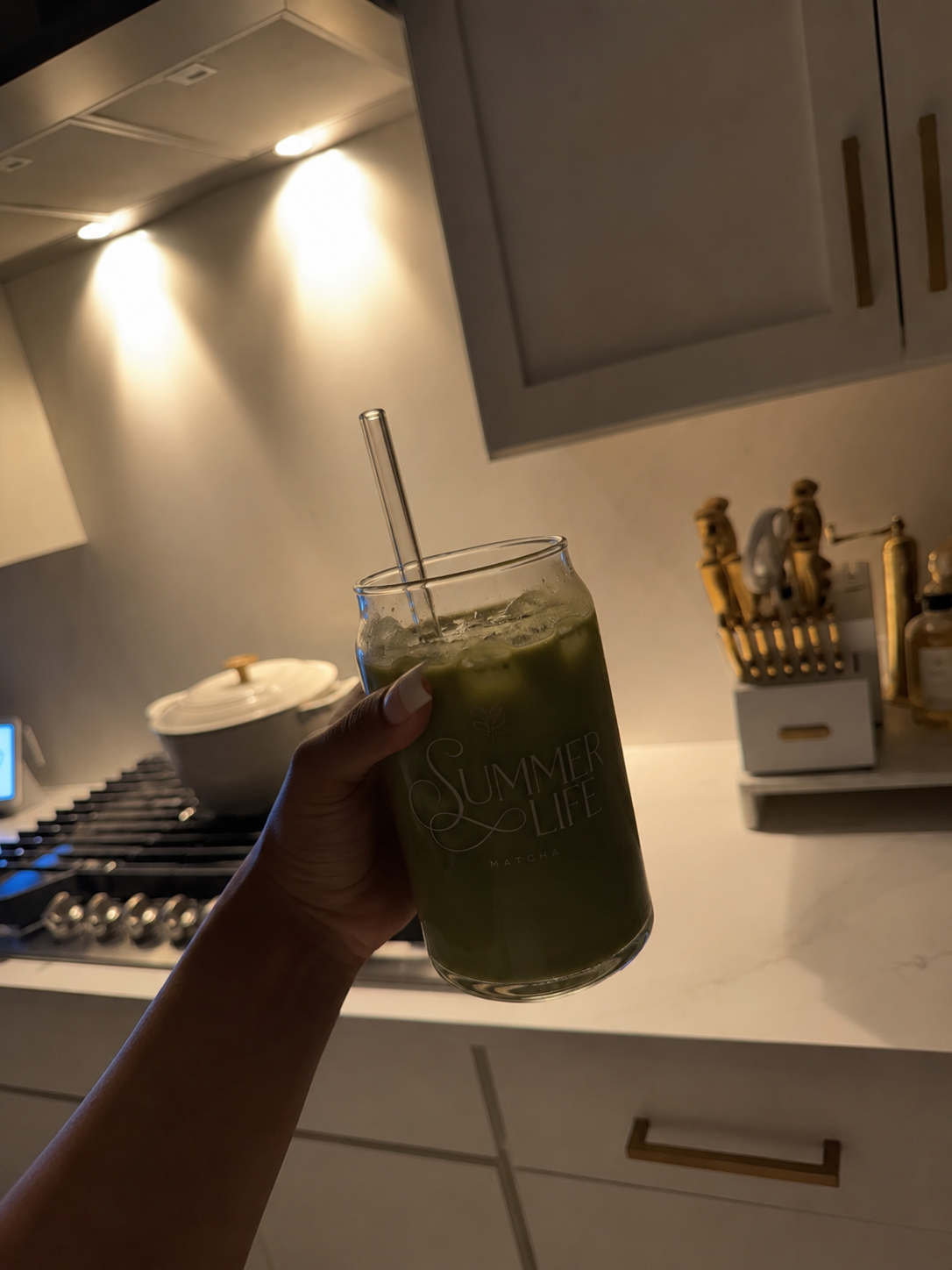 Hand holding a Summer Life Matcha branded glass cup